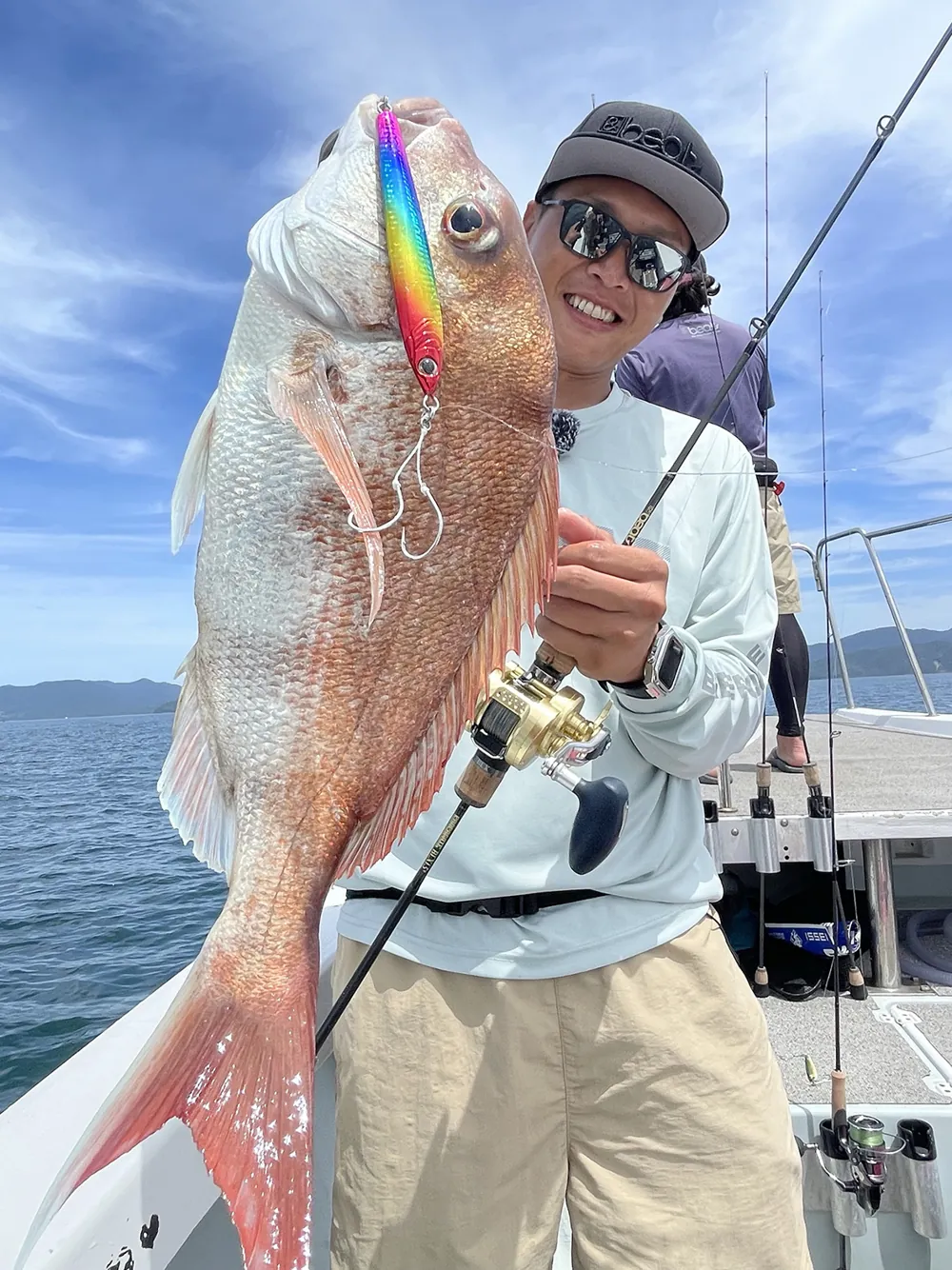 ジグで釣り上げたマダイを掲げる大橋正義氏
